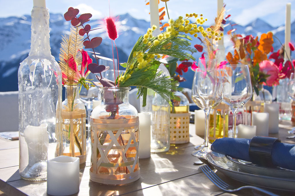 Fleuriste : soliflores de fleurs très colorées sur une table dressée devant les montagnes 