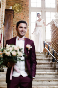 Mariage thème Harry Potter découverte du couple le marié attend la mariée en bas des escaliers avec le bouquet