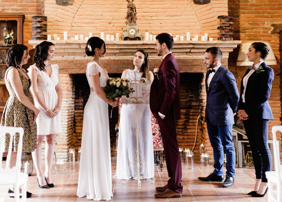 Mariage thème Harry Potter : cérémonie laïque devant la cheminée pleine de bougie. Les mariés au centre avec l'officiante derrière et les témoins de part et d'autre.
