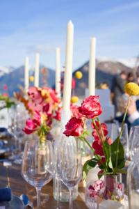 Mariage à la montagne table dressée avec la montagne en fond avec des chandelles et fleurs très colorées