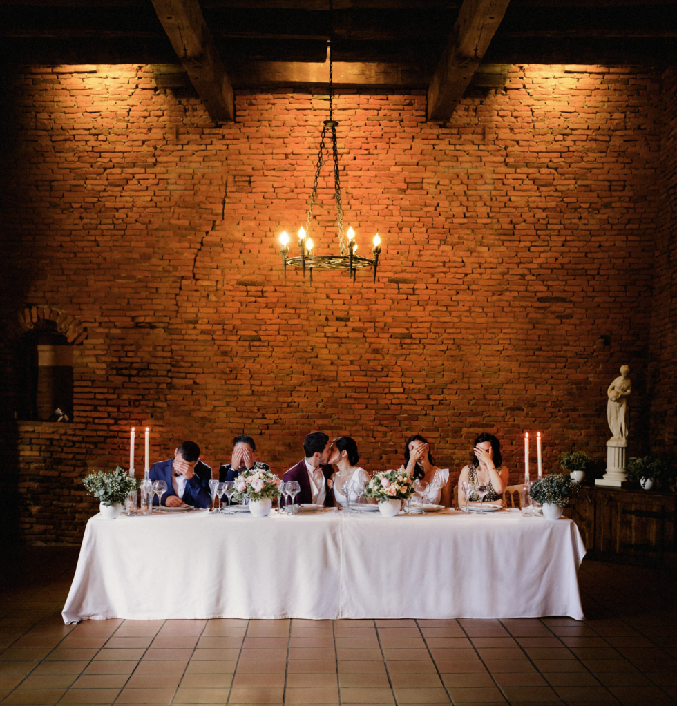 Mariage thème Harry Potter. Les mariés au centre de la table rectangulaire s'embrassent pendant que les témoins de part et d'autre se cachent les yeux