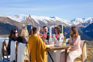 Mariage à la montagne repas avec la table dressée. Chandelles, fleurs colorée et la montagne trône en fond